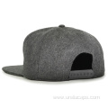 Woolen snapback cap with rubber badge